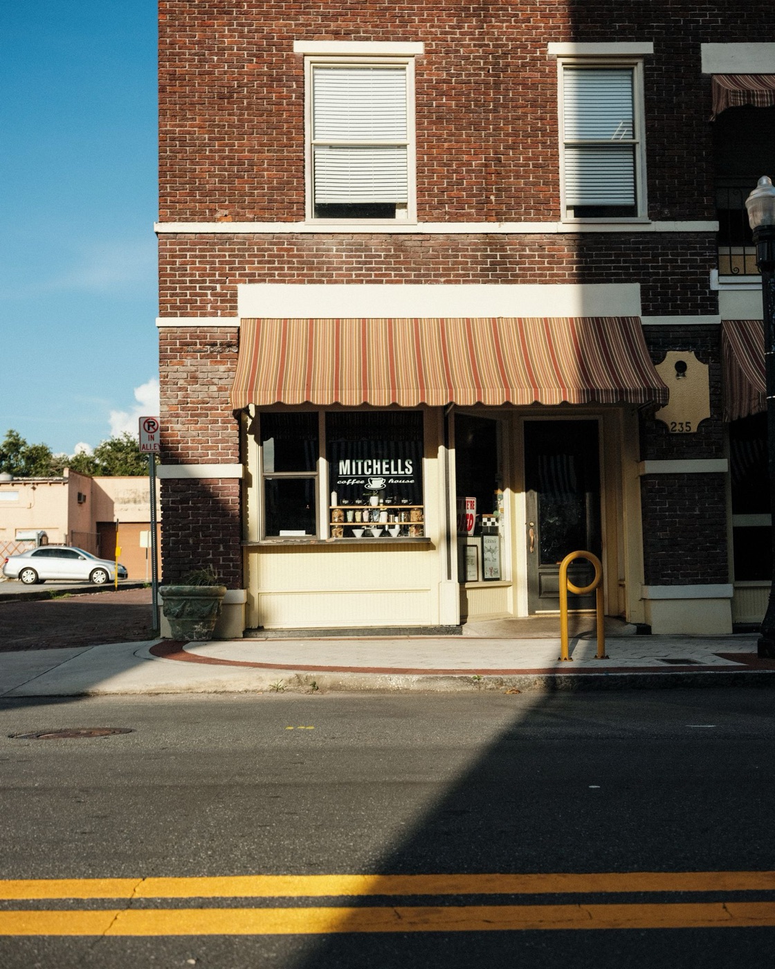 Brick storefront with a striped awning on a small-town main street