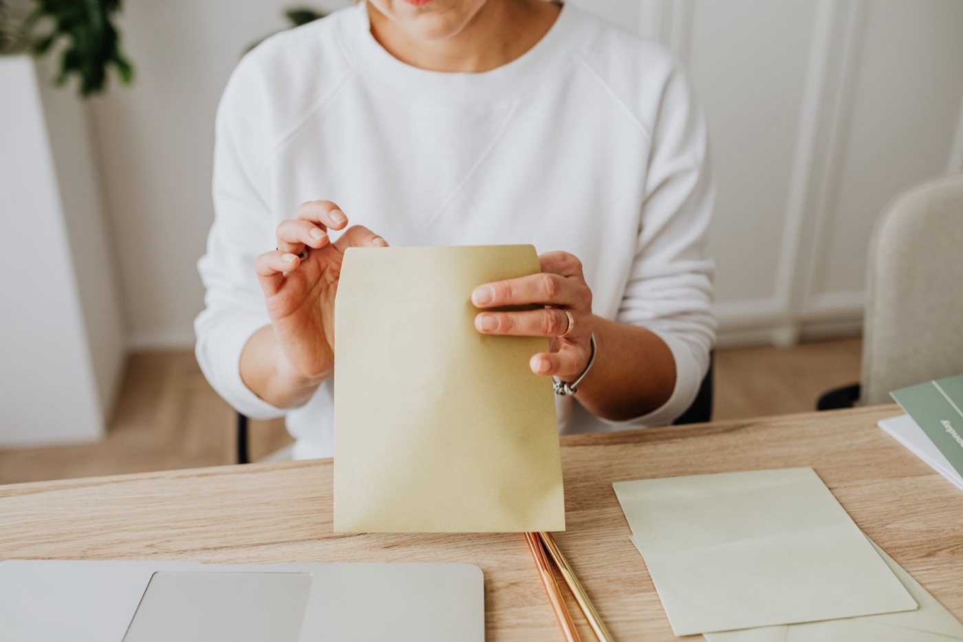 Sealing a manila envelope at a wooden desk